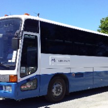 a blue bus parked on the side of a road